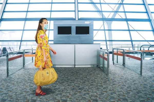 全身上下都是年轻的游客 拿着一个包 头戴口罩 站在机场防范考拉威斯 — 图库照片