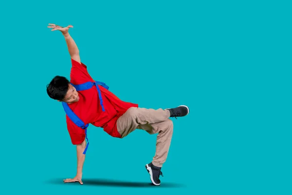 Atrakcyjny Chłopiec Wykonujący Taniec Freestyle Studio Niosąc Torbę Niebieskim Tłem — Zdjęcie stockowe