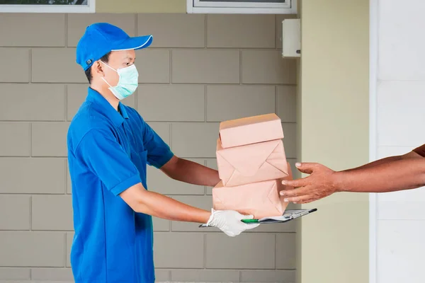 Retrato Homem Vestindo Uniforme Entrega Azul Máscara Facial Dando Pilha — Fotografia de Stock