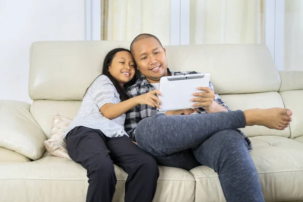 Jovem Sua Filha Usando Tablet Digital Juntos Enquanto Sentados Sofá — Fotografia de Stock