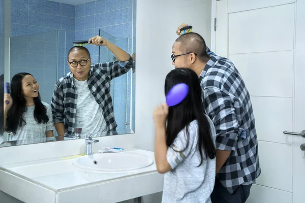 バスルームに一緒に立っている間 鏡の前で父親と一緒に髪を持っている小さな女の子 4Kの解像度で撮影 — ストック写真