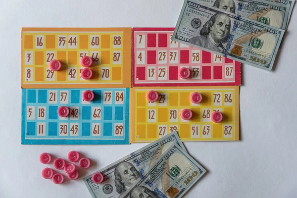 Colorful lotto or bingo game papers with numbers and plastic lotto barrels.