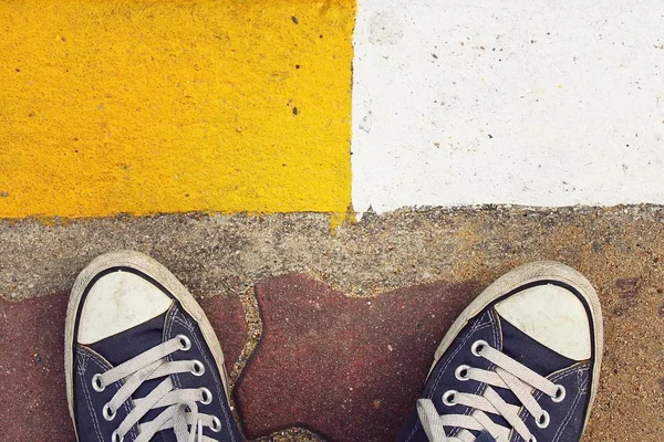 Blue sneakers from an aerial view on concrete block pavement. Top view, feeling between choose, choice.