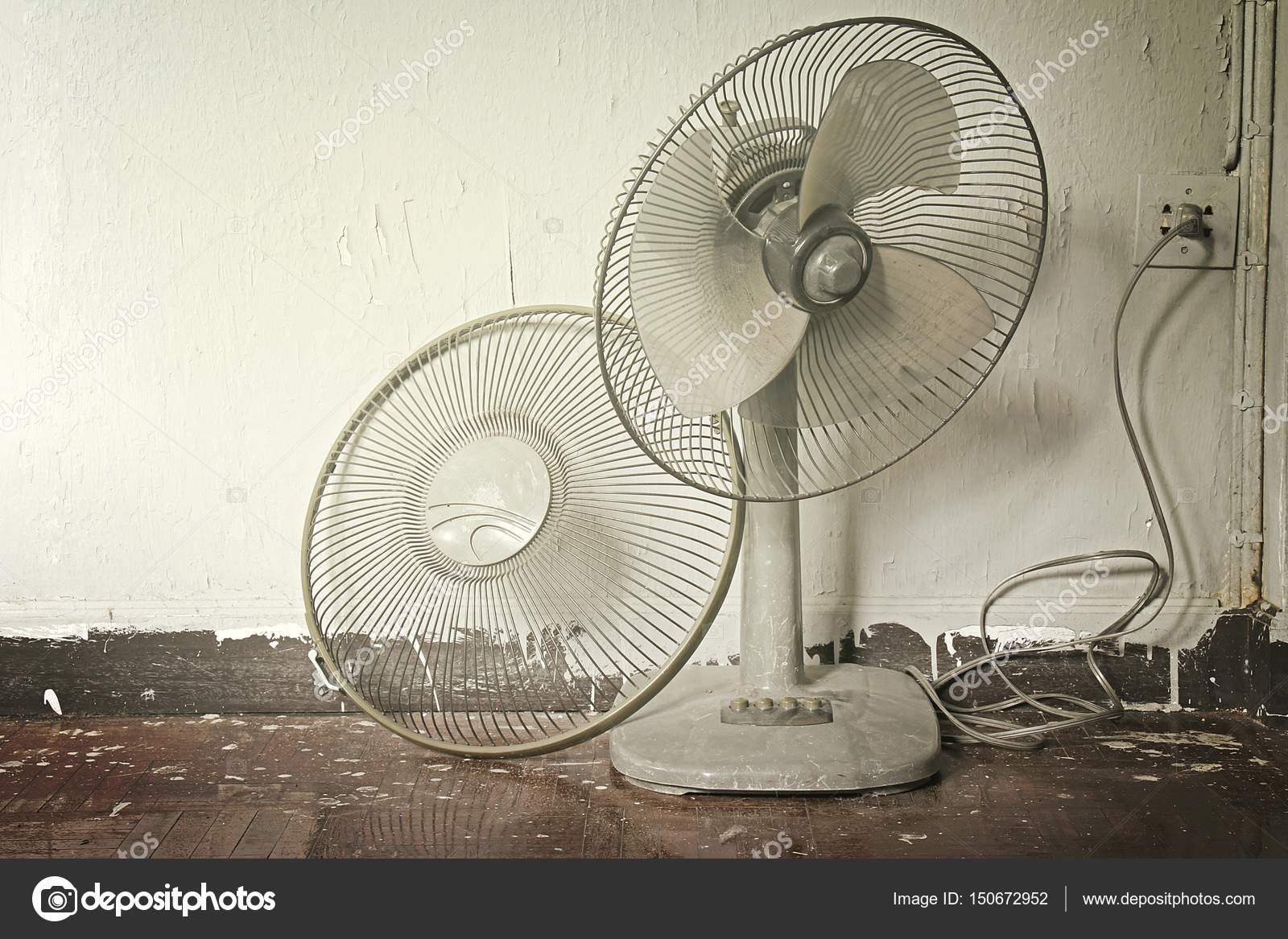 Dirty broken old electric fan in hot weather. Stock Photo by