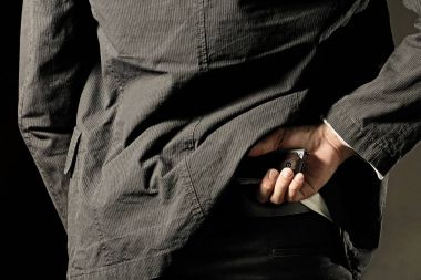 Bir adam, polis ya da silahını arkasından gizlemek gangster