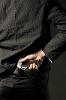 Gizli silah. Bir adam, polis ya da silahını arkasından gizlemek gangster