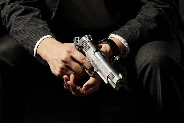 Man Holding Gun seduto sulla sedia . — Foto Stock