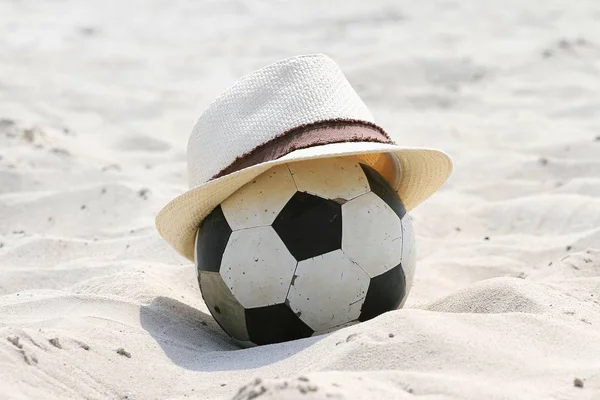 Летняя концепция. Соломенная шляпа и футбол на пляже. Расслабиться . — стоковое фото