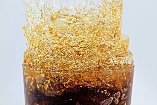 Salpicadura de hielo cristalino, Salpicadura de cola en un vaso con hielo, Cristales de hielo abstractos . —  Fotos de Stock