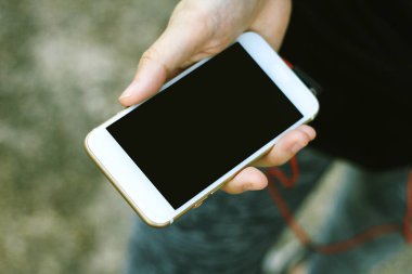 Boş siyah perde ile beyaz cep telefonu tutan el mockup görüntü.