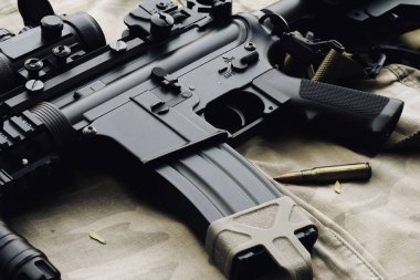 Bir M4a1, yakın çekim silah ve askeri teçhizat için ordu, saldırı tüfeği silah ve tabanca kamuflaj arka plan üzerinde.
