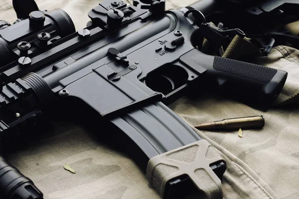 Primer plano de un M4A1 armas y equipo militar para el ejército, pistola y rifle de asalto sobre fondo de camuflaje . —  Fotos de Stock