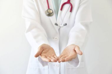 Doktor elini yakın boş avuç bir şey tutan kadın doktoru sunulması.