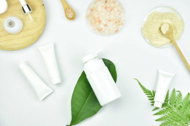 Kozmetik şişe kapları ile yeşil bitki yaprakları, mock-up marka için boş etiket paketi