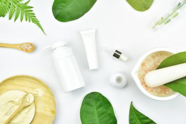 Kozmetik şişe kapları ile yeşil bitki yaprakları, mock-up marka için boş etiket paketi