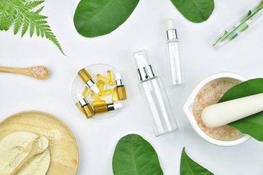Kozmetik şişe kapları ile yeşil bitki yaprakları, mock-up marka için boş etiket paketi