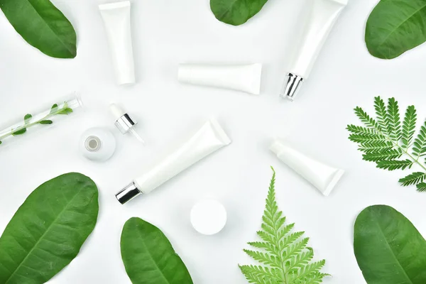 Contenitori cosmetici per bottiglie con foglie di erbe verdi, confezione con etichetta bianca per il modello di branding — Foto Stock