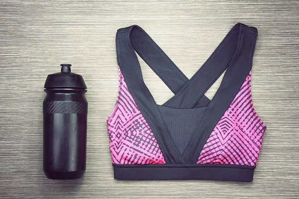 Women's sports bra and Black Bicycle water bottle. Sport accessories and fashion.