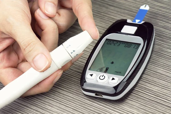 Close-up of Woman Hands Testing High Blood Sugar With Glucometer.