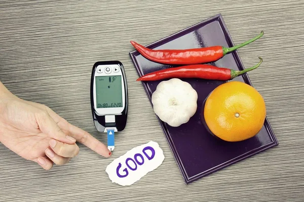 Blodsocker mätningen, diabetiker kit, blodglukos meter test och örter. Hälsosam mat äta koncept. Orange, vitlök, chili. — Stockfoto