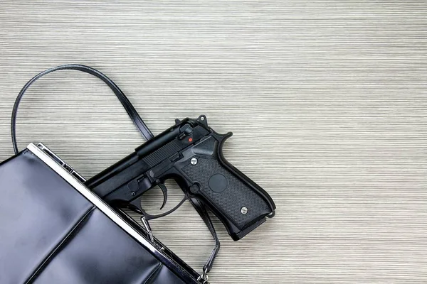 Bolso de mujer con arma oculta, pistola cayendo del bolso de una mujer . — Foto de Stock