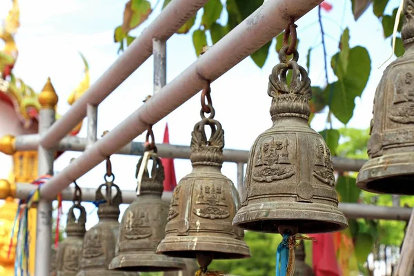 Колокол в храме. Ряд золотых колоколов в буддийском храме, медные колокола висят в храме ряд, Таиланд — стоковое фото
