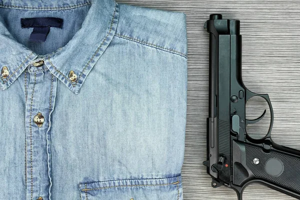 Mannen killer, slimme en aantrekkelijke stijl, Blue jeans overhemd en pistool. — Stockfoto