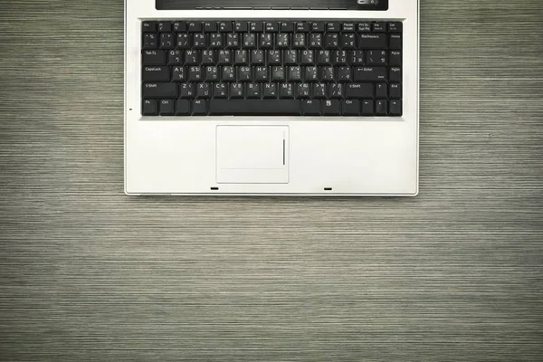 Laptop on wood table, Close up at laptop keyboard.