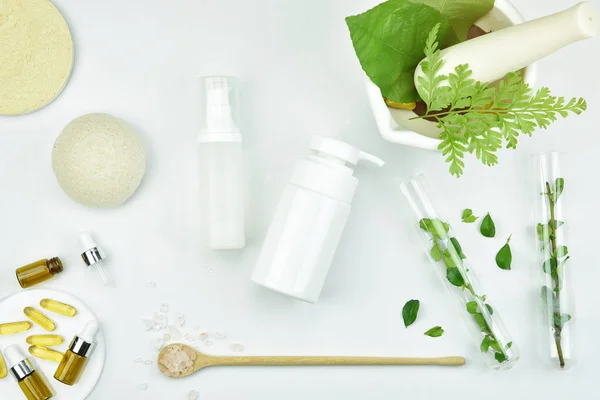 Kontainer botol kosmetik dengan daun herbal hijau, paket label kosong untuk merek tiruan, konsep produk kecantikan organik alami . — Stok Foto