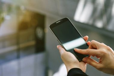 Cep telefonunuzun veya smartphone şehrin haber okuma portre el tutun. 