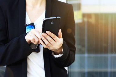 Şehirde akıllı telefon kullanan genç şık kadın.