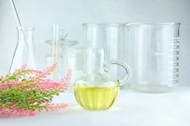 Doğal temel aroma yağı, bitkisel organik ayıklama yağı ile laboratuvar cam arka plan.