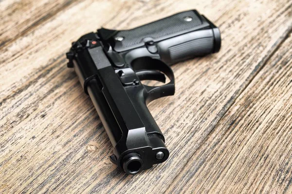 Pistola semiautomática apoyada sobre fondo de madera., pistola 9mm, cañón de acercamiento. (Enfoque selectivo ) —  Fotos de Stock