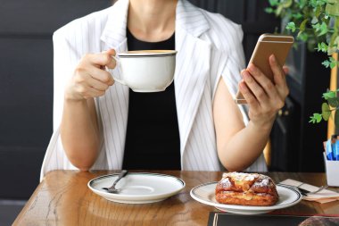 Kahve içme ve Cafe, cafe bar, kahve molası rahatlatıcı onun kahve molası üzerinde çalışan iş kadın akıllı telefon kullanan genç iş kadını.