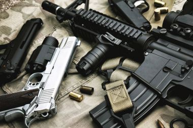 Silah ve askeri teçhizat ordusu, taarruz tüfeği topu (M4a1) ve kamuflaj arka plan üzerinde tabanca.