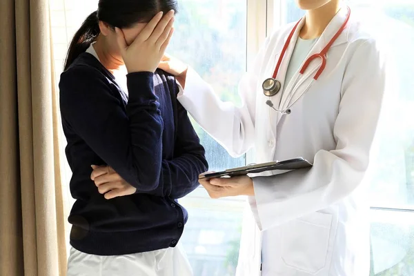 Patientin erhält schlechte Nachrichten, sie ist verzweifelt und weint, der Arzt unterstützt und tröstet ihre Patientin mit Anteilnahme. — Stockfoto