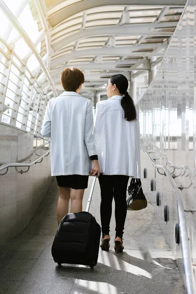 年轻的商界女强人穿行旅客登机桥，商务旅行的概念时拉行李箱. — 图库照片