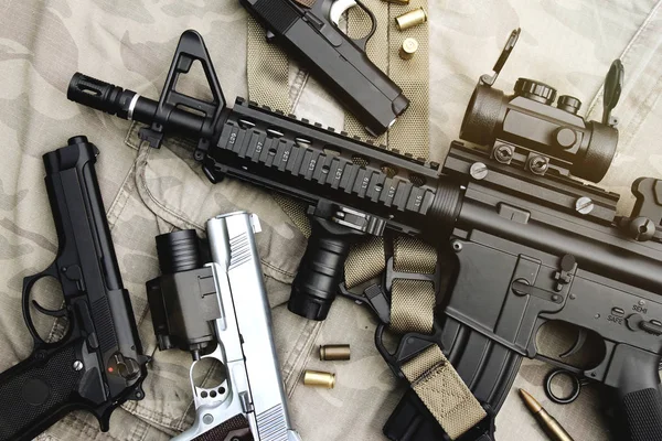Armas e equipamentos militares para exército, fuzil de assalto (M4A1) e pistola em fundo de camuflagem . — Fotografia de Stock