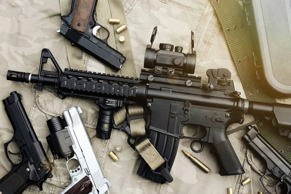 Armas y equipo militar para el ejército, rifle de asalto (M4A1) y pistola sobre fondo de camuflaje . —  Fotos de Stock