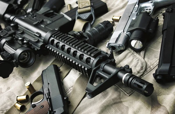 Armas e equipamentos militares para exército, fuzil de assalto (M4A1) e pistola em fundo de camuflagem . — Fotografia de Stock