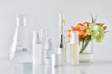 Kozmetik şişe kapları ile yeşil bitki yaprakları ve bilimsel Züccaciye Mağazaları, boş etiket mock-up, araştırma marka için paket ve doğal organik güzellik Cilt Bakımı geliştirmek 