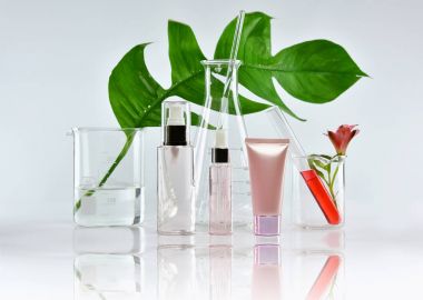 Kozmetik şişe kapları ile yeşil bitki yaprakları ve bilimsel Züccaciye Mağazaları, boş etiket mock-up, araştırma marka için paket ve doğal organik güzellik cilt bakım ürünü geliştirmek.