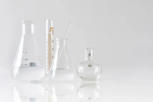 Gruppo di vetrerie da laboratorio scientifiche con soluzione liquida chiara, concetto di ricerca e sviluppo . — Foto Stock
