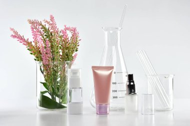 Yeşil bitkisel yapraklı kozmetik şişe kapları ve bilimsel cam eşyalar, markalaştırma, araştırma ve doğal organik güzellik ürünleri konseptini geliştirmek için boş etiket paketi..