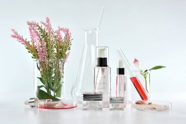 Kozmetik şişe kapları pembe bitki yaprakları ve bilimsel Züccaciye Mağazaları, boş etiket ile marka mock-up, araştırma için paket ve doğal organik güzellik Cilt Bakımı ürün konsept geliştirmek.