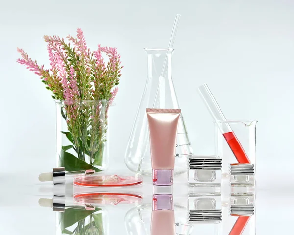 Kozmetik şişe kapları pembe bitki yaprakları ve bilimsel Züccaciye Mağazaları, boş etiket ile marka mock-up, araştırma için paket ve doğal organik güzellik Cilt Bakımı ürün konsept geliştirmek.