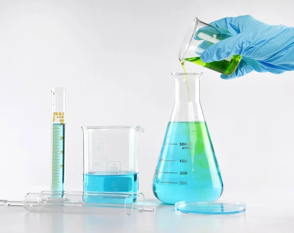 Químico formulando substâncias perigosas solução, Cientista com equipamentos e experimentos científicos, copos de laboratório contendo líquido químico tóxico . — Fotografia de Stock