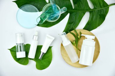 Yeşil bitkisel yapraklı kozmetik şişe kapları, markalaşma için boş etiket, doğal güzellik ürünü konsepti.