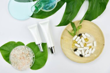 Yeşil bitkisel yapraklı kozmetik şişe kapları, markalaşma için boş etiket, doğal güzellik ürünü konsepti.