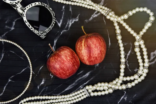 苹果果维生素作为自然化妆品, 妇女配件, 太阳眼镜, 珍珠项链, 顶头带和苹果在大理石背景. — 图库照片